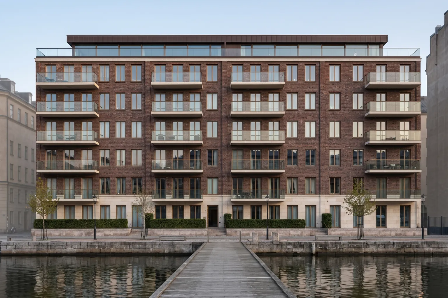 Vassmoras fasad mot vattnet med alla lägenheter, rakt framifrån från bryggan — illustrativ visualisering